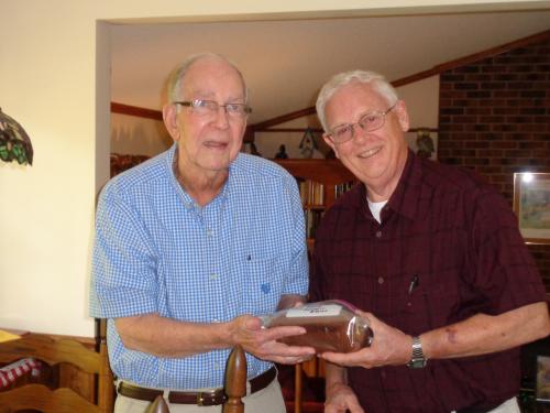 Bob handing Paul a loaf of Betty Ann's homemade pumpkin bread.